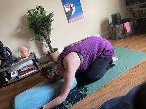 Demonstrating child's pose with bolster