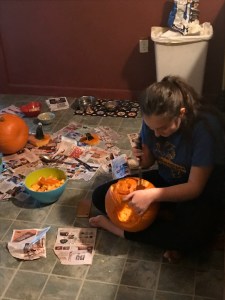 Daughter carving pumpkin